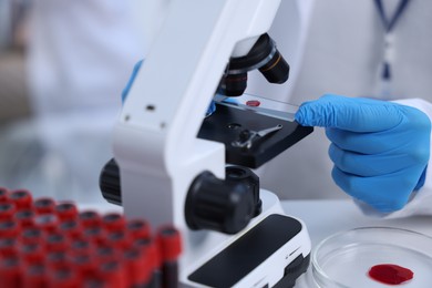 Scientist working with microscope in laboratory, closeup