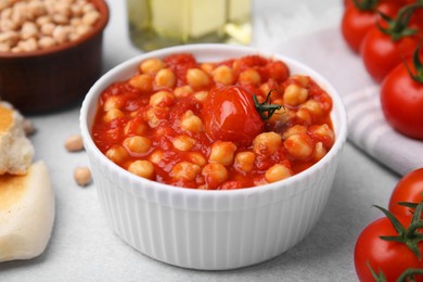 Photo of Delicious chickpea curry in bowl on light gray table, closeup