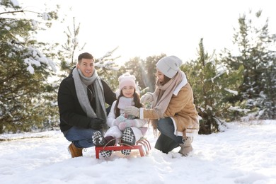 Photo of Happy family with sledge outdoors on winter day. Christmas vacation
