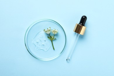 Photo of Petri dish with sample of cosmetic oil, pipette and beautiful flowers on light blue background, flat lay