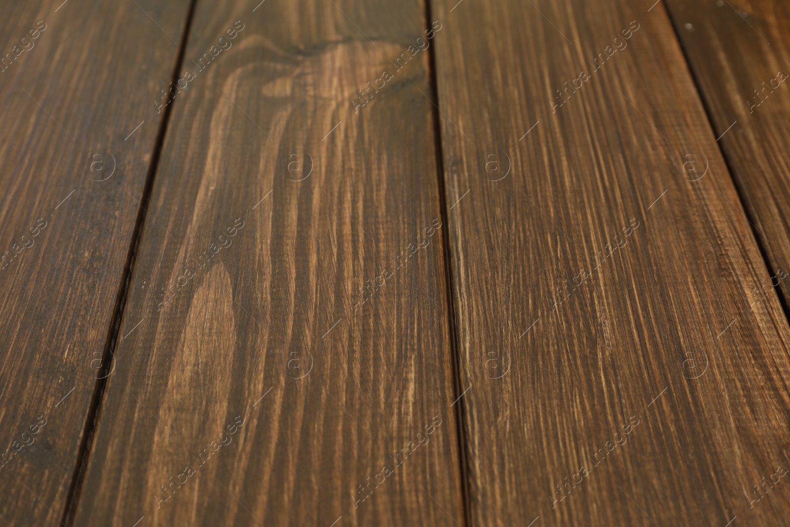 Photo of Wooden surface covered with wood stain, closeup