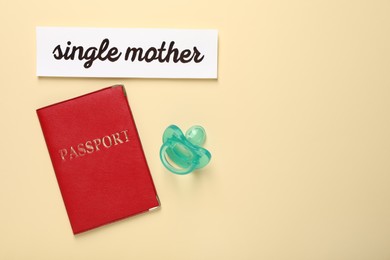 Being single mother concept. Passport, pacifier and card on beige background, flat lay with space for text