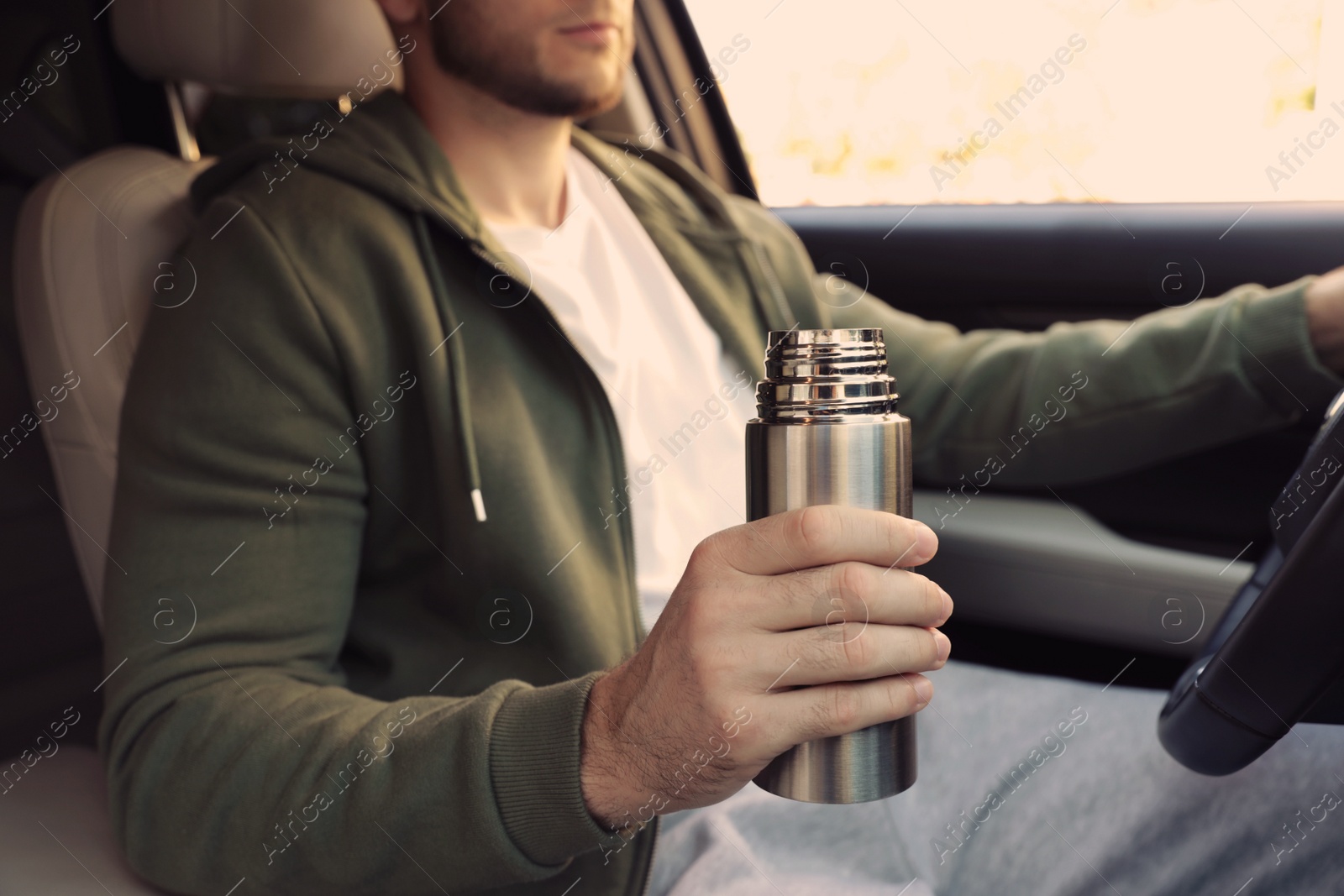 Photo of Man with thermos driving car, closeup view