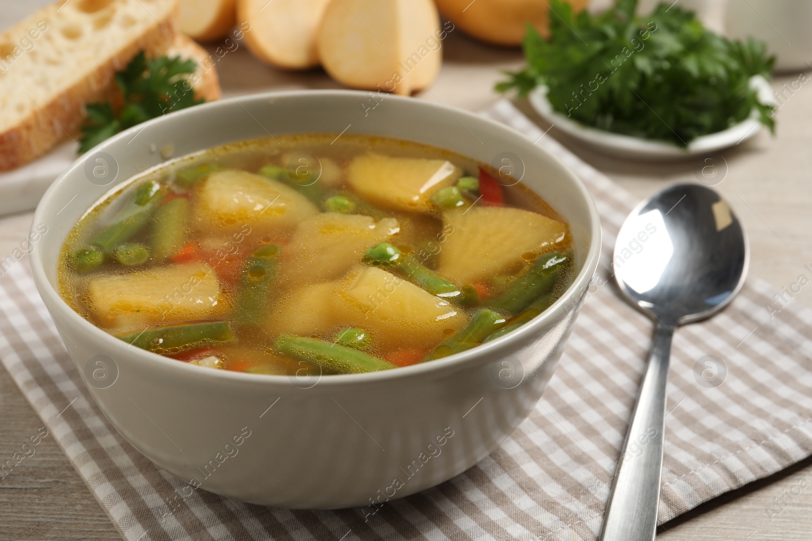 Photo of Bowl of delicious turnip soup served on wooden table