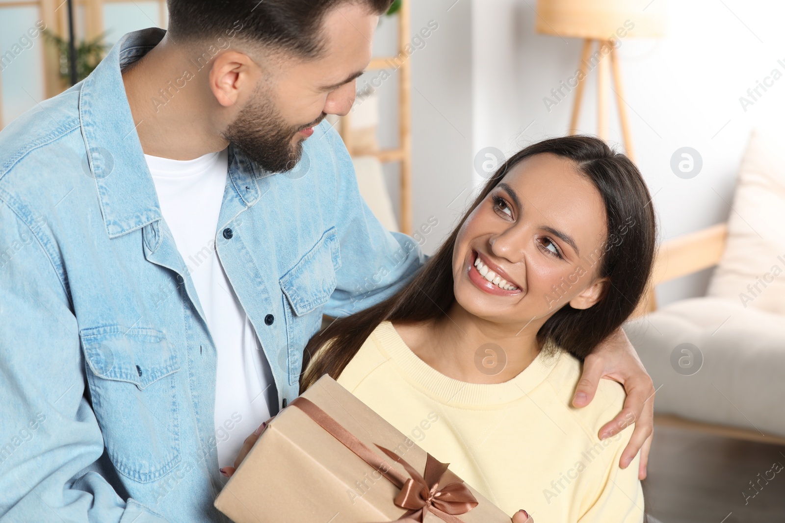 Photo of Lovely couple with beautiful gift at home