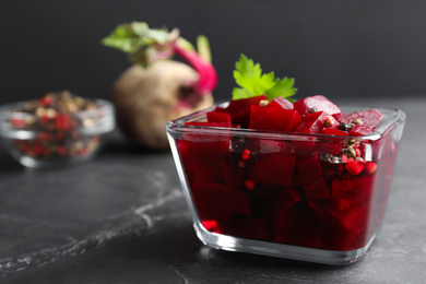 Pickled beets in glass bowl on dark marble table