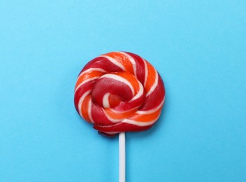 Photo of Sweet colorful lollipop on light blue background, top view