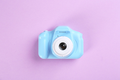 Light blue toy camera on pink background, top view