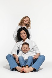 Photo of Little children with their mother on white background