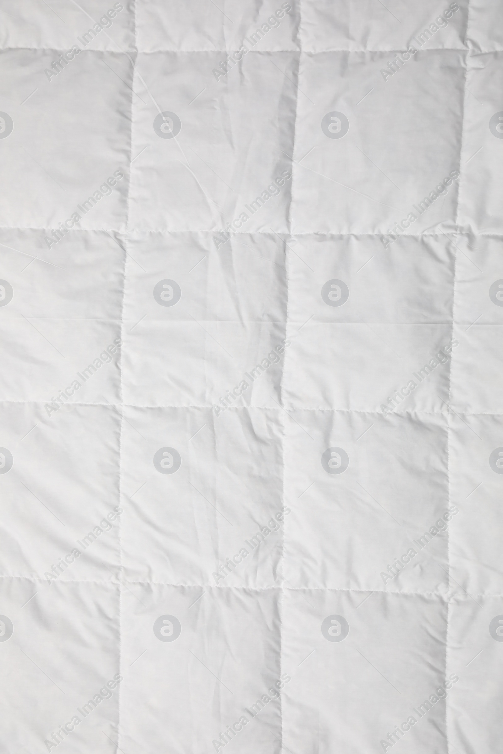 Photo of Soft quilted blanket as background, top view