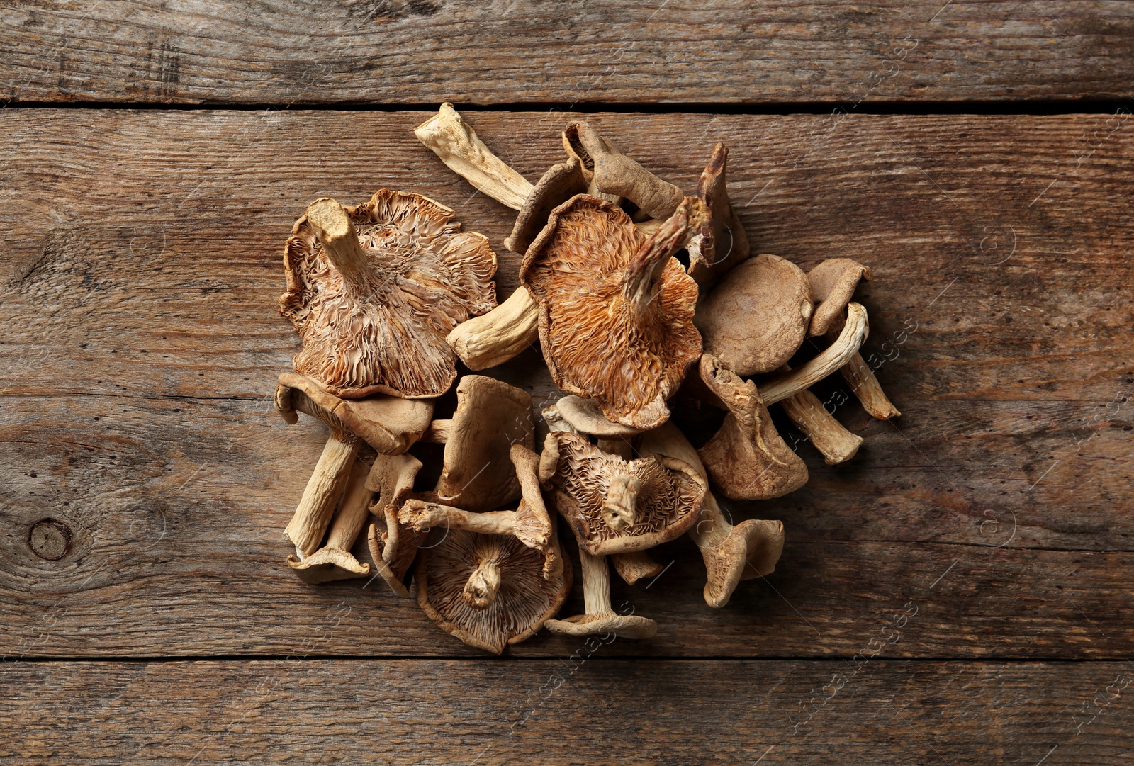 Photo of Delicious dried mushrooms on wooden background, top view