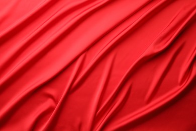 Photo of Crumpled red silk fabric as background, top view