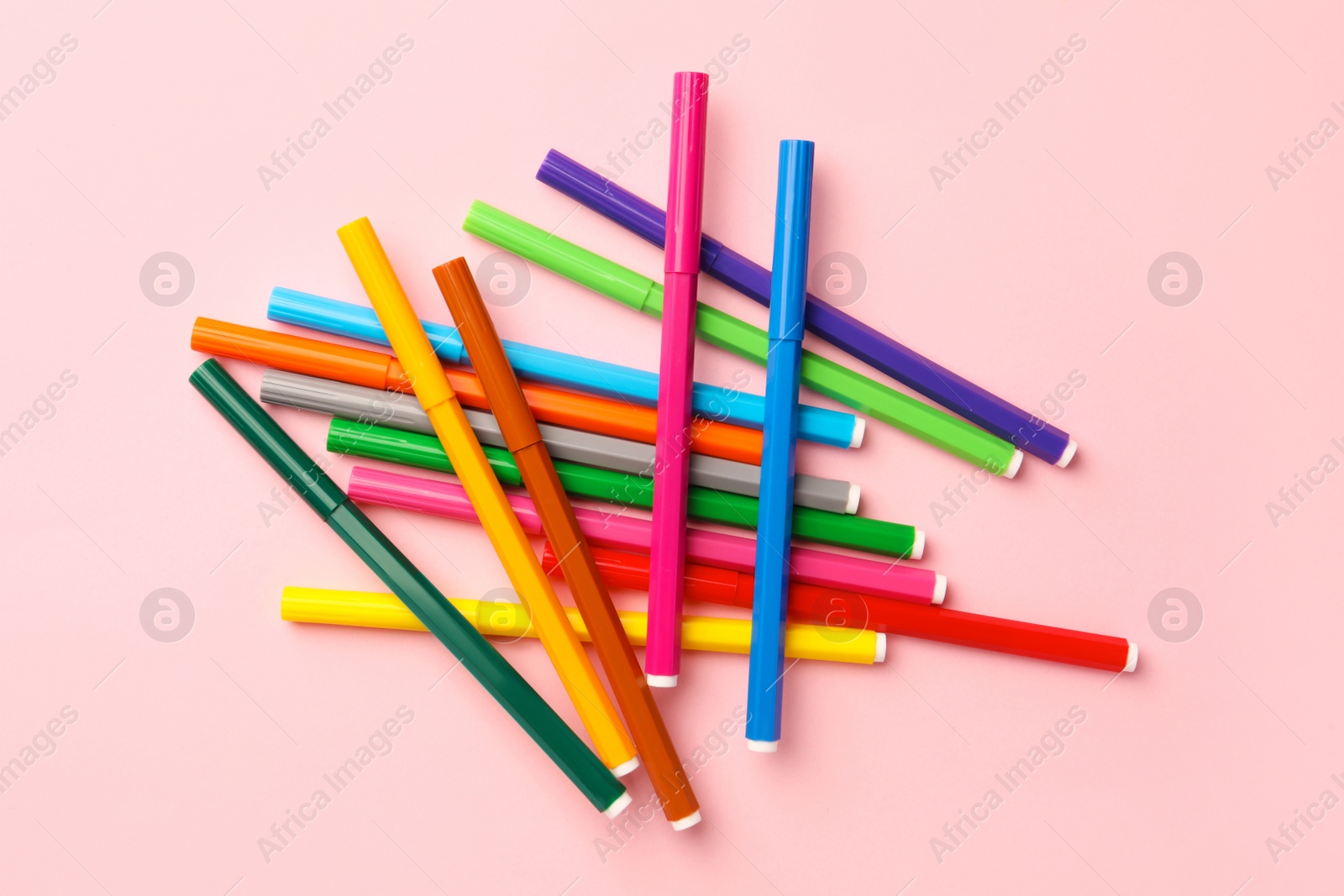 Photo of Many bright markers on pink background, flat lay