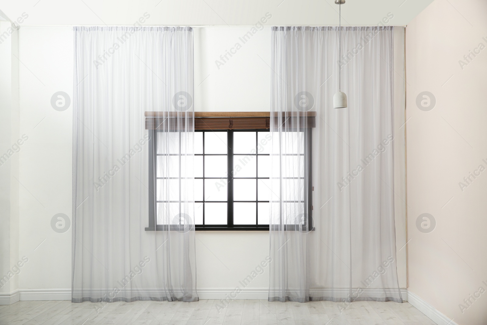 Photo of Window with beautiful curtains and open blinds in empty room