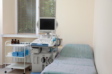 Photo of Ultrasound machine, medical trolley and examination table in hospital