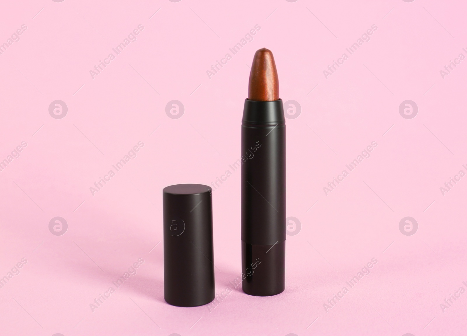 Photo of Bright lipstick in black tube on pink background