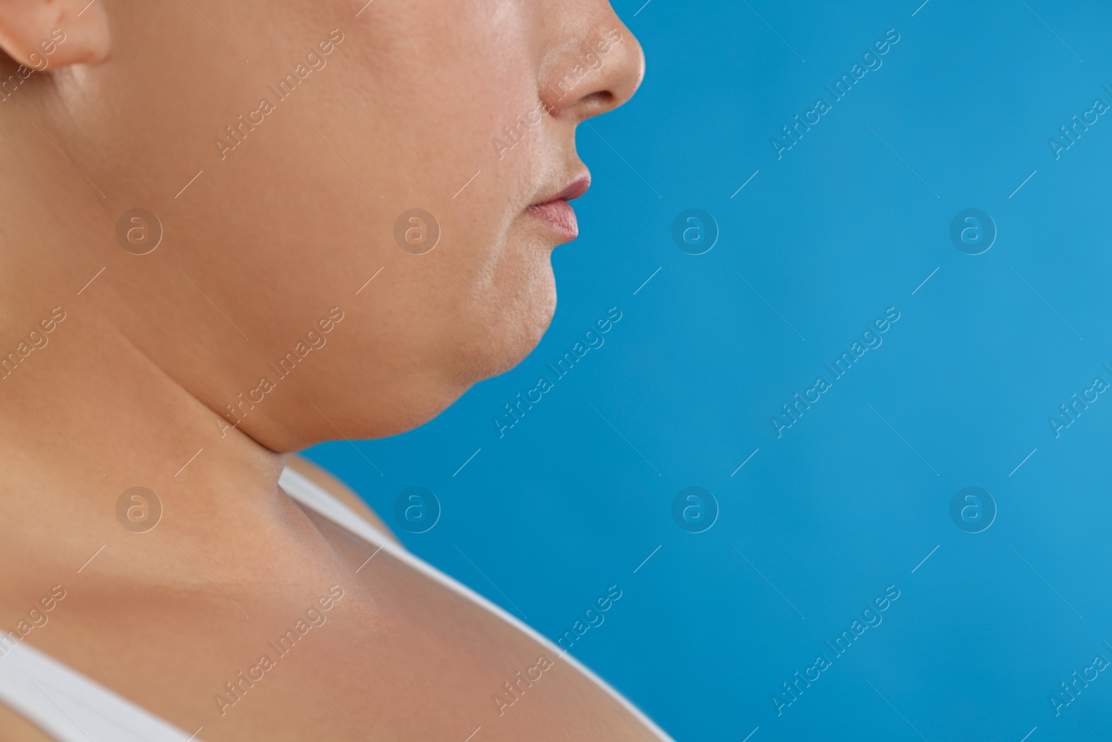 Photo of Woman with double chin on blue background, closeup. Space for text