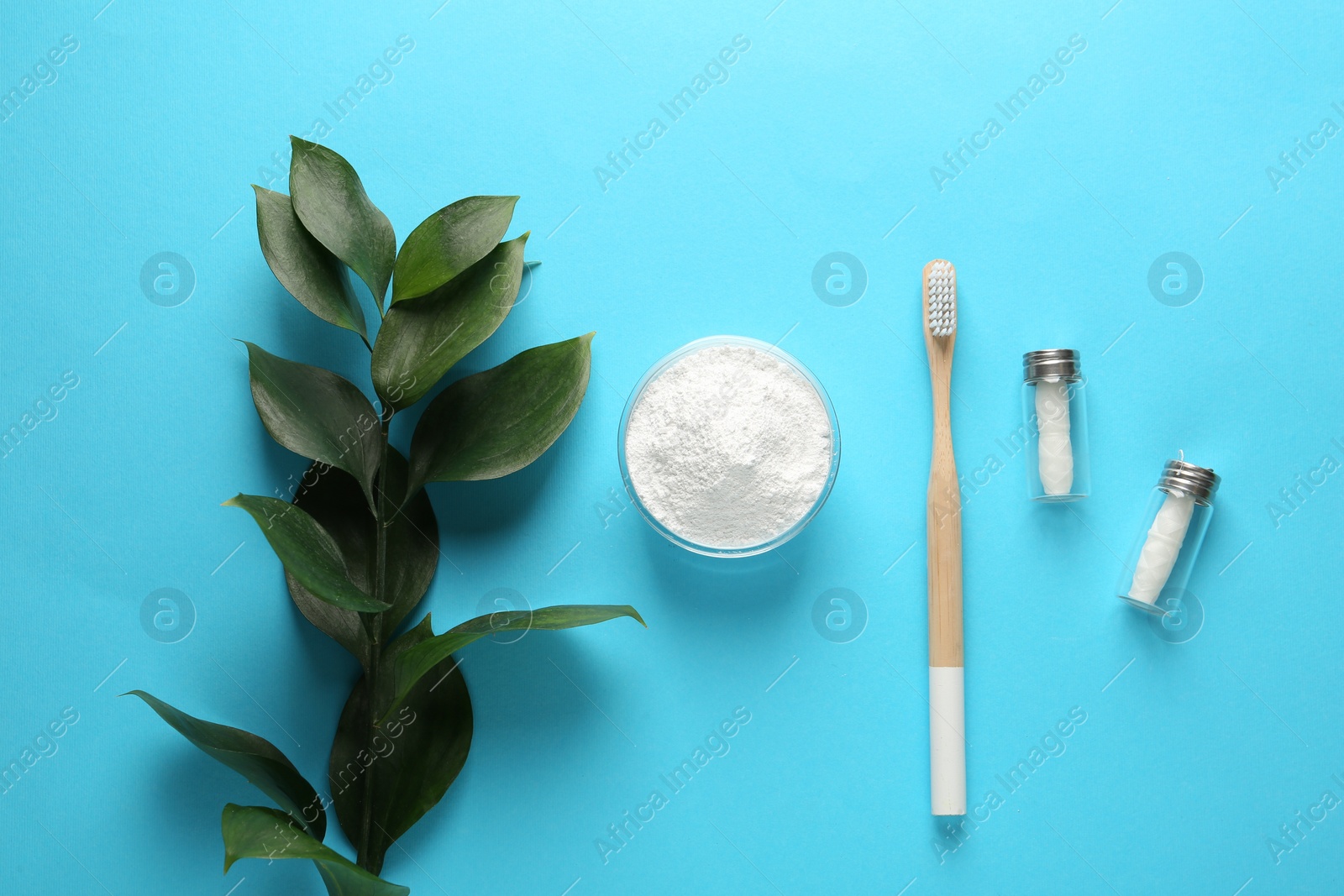 Photo of Bowl of tooth powder, brush, dental flosses and plant on turquoise background, flat lay. Space for text