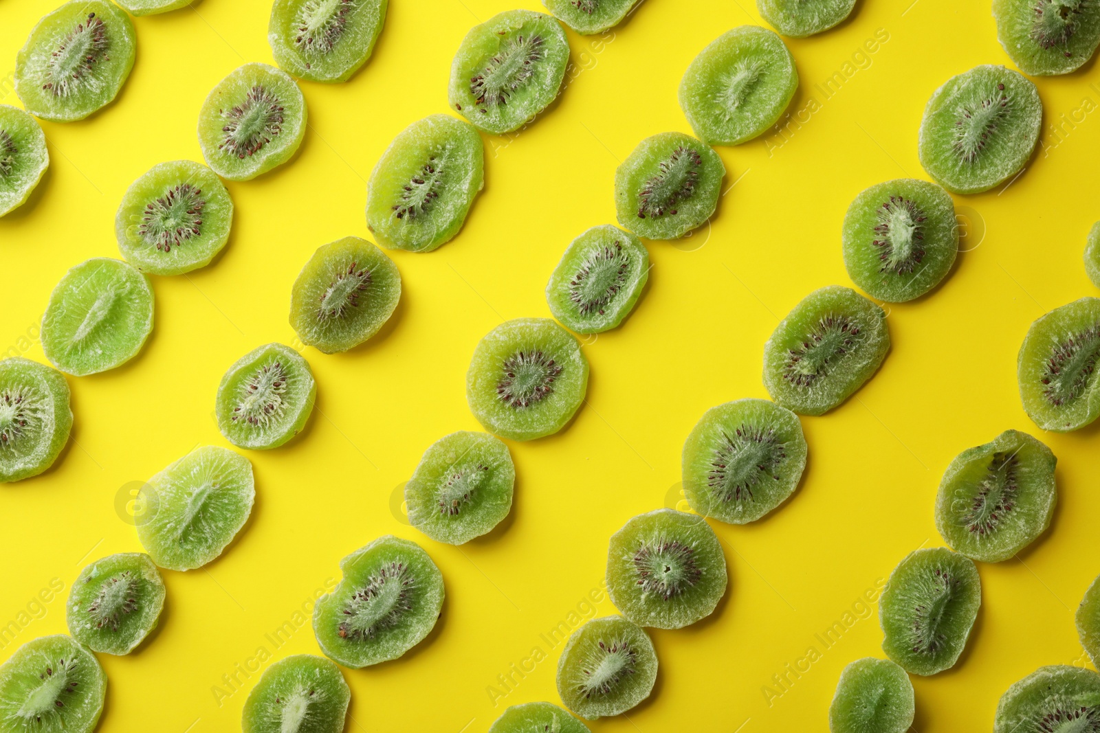 Photo of Slices of kiwi on color background, flat lay. Dried fruit as healthy food