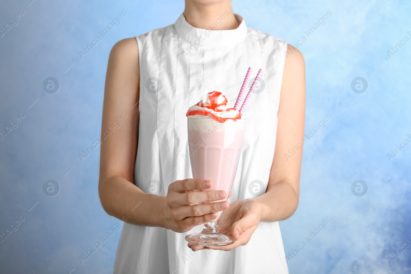 Photo of Woman holding glass with delicious milk shake on color background