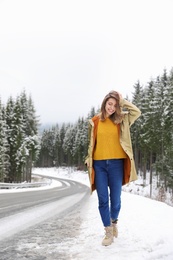 Photo of Young woman walking near snowy forest. Winter vacation