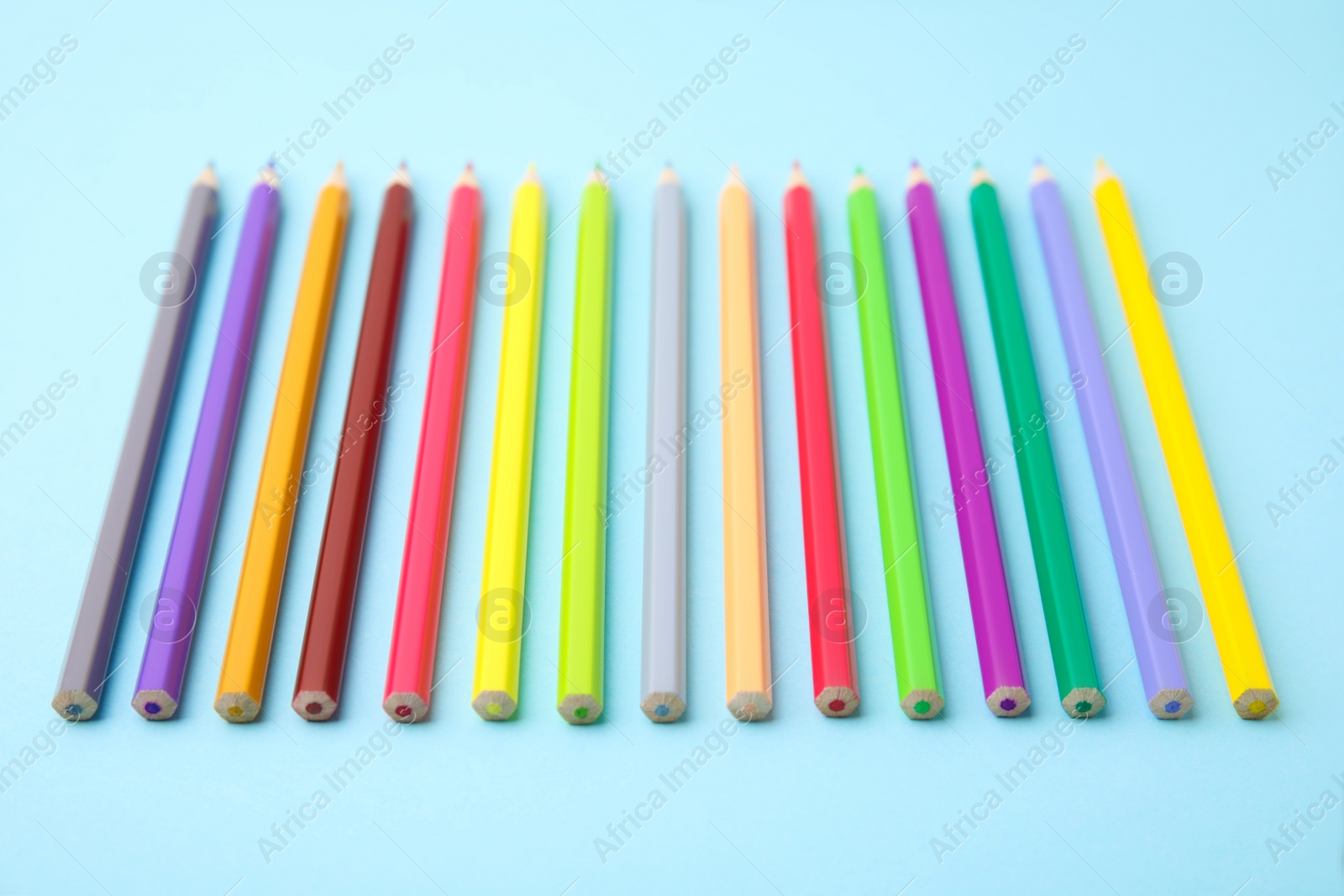 Photo of Colorful wooden pencils on light blue background