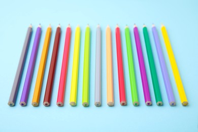 Colorful wooden pencils on light blue background