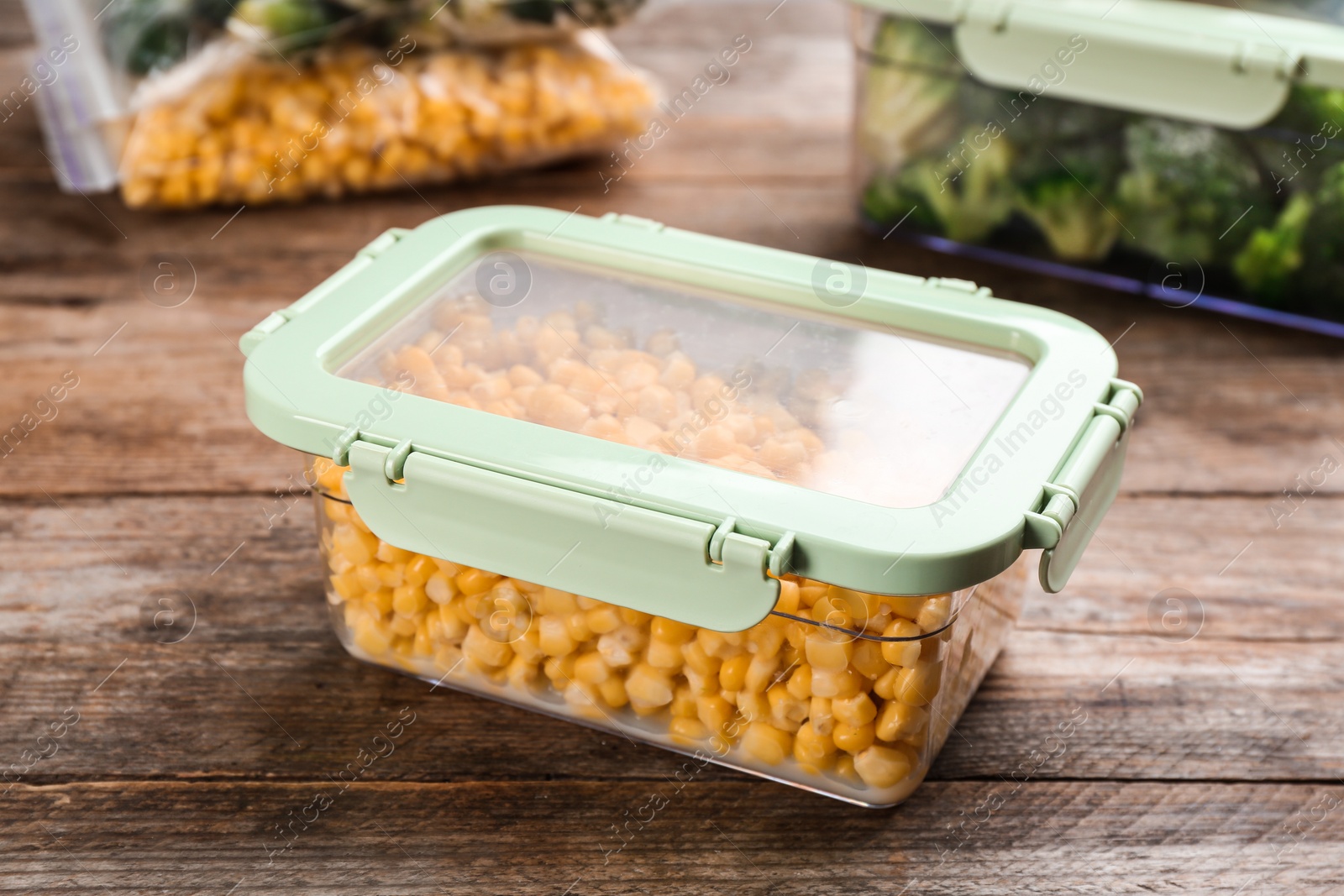 Photo of Frozen sweet corn on wooden table. Vegetable preservation