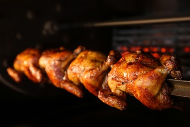 Photo of Grilling whole chickens in rotisserie machine, closeup