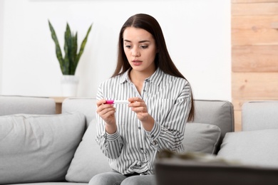 Young woman with pregnancy test at home. Gynecology and childbirth