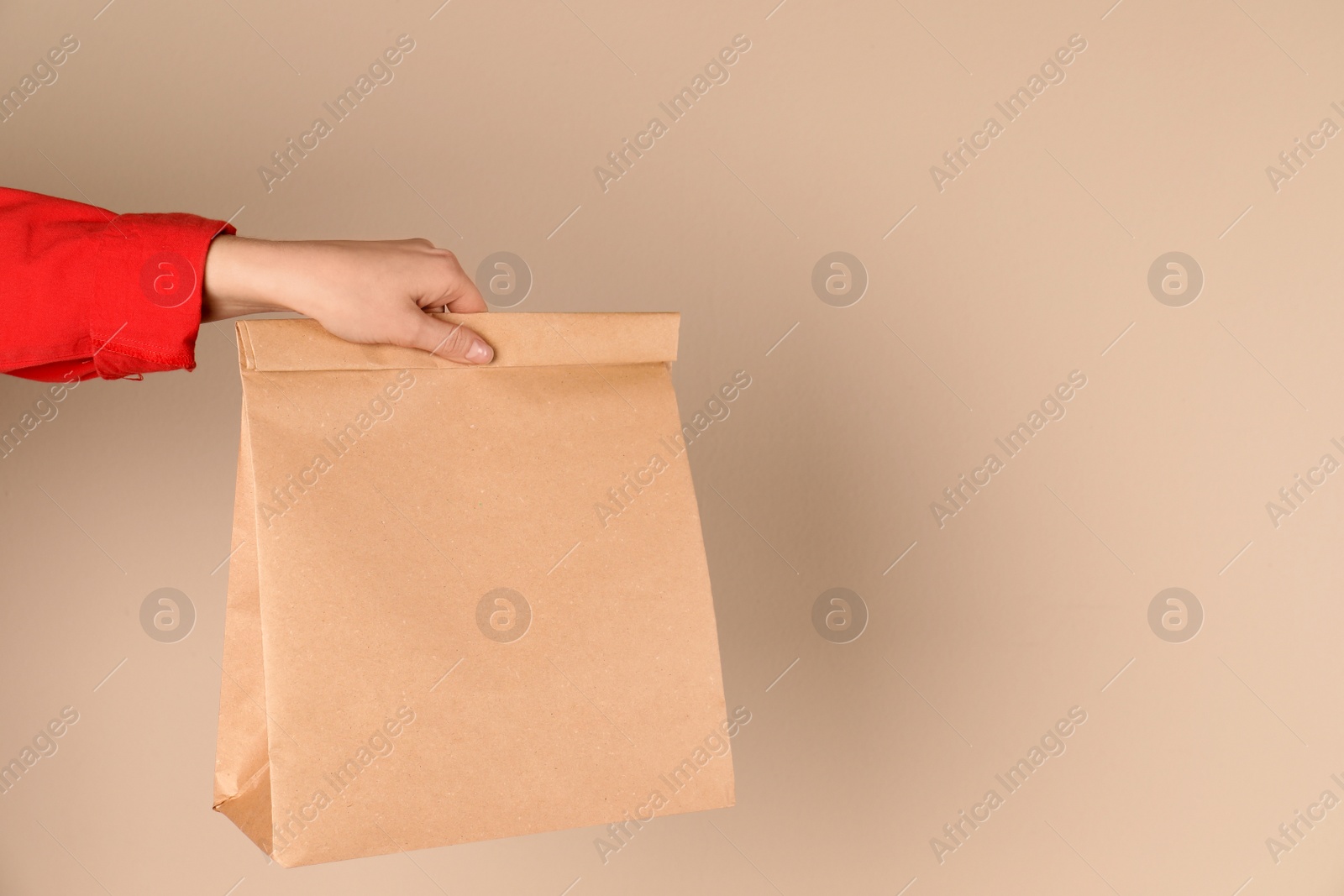 Photo of Woman holding paper bag on color background. Mockup for design