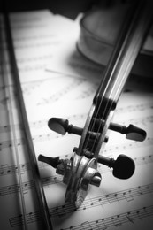 Image of Classic violin, bow on note sheets, closeup. Black and white tone