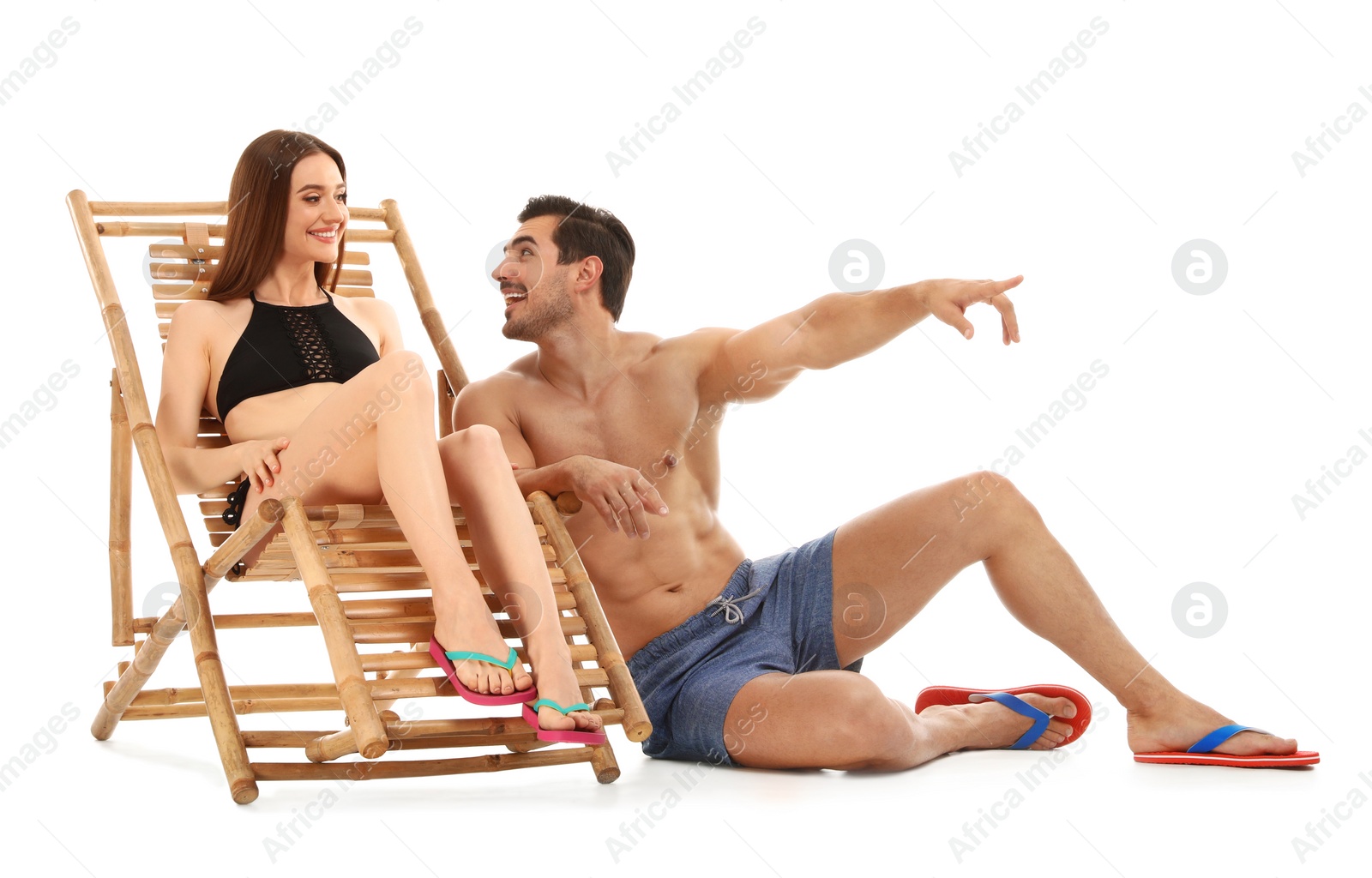 Photo of Young couple with sun lounger on white background. Beach accessories