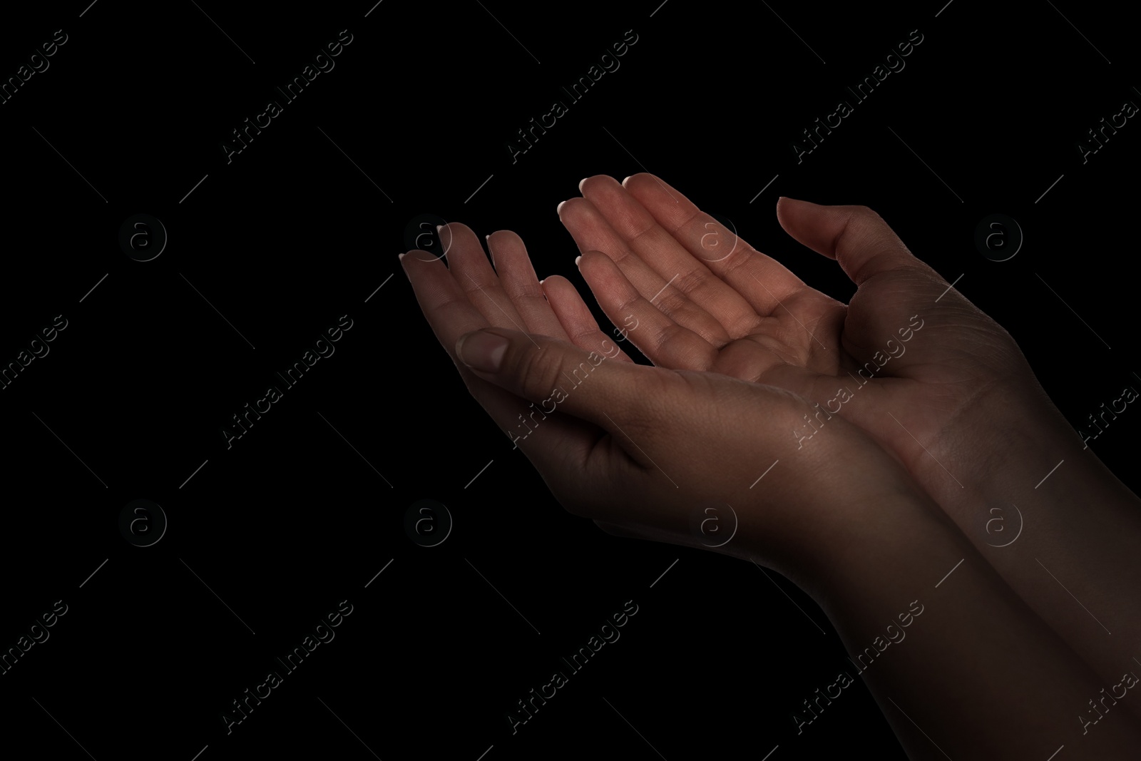 Image of Christian woman praying in darkness, closeup. Space for text