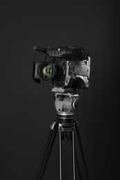 Modern professional video camera on black background
