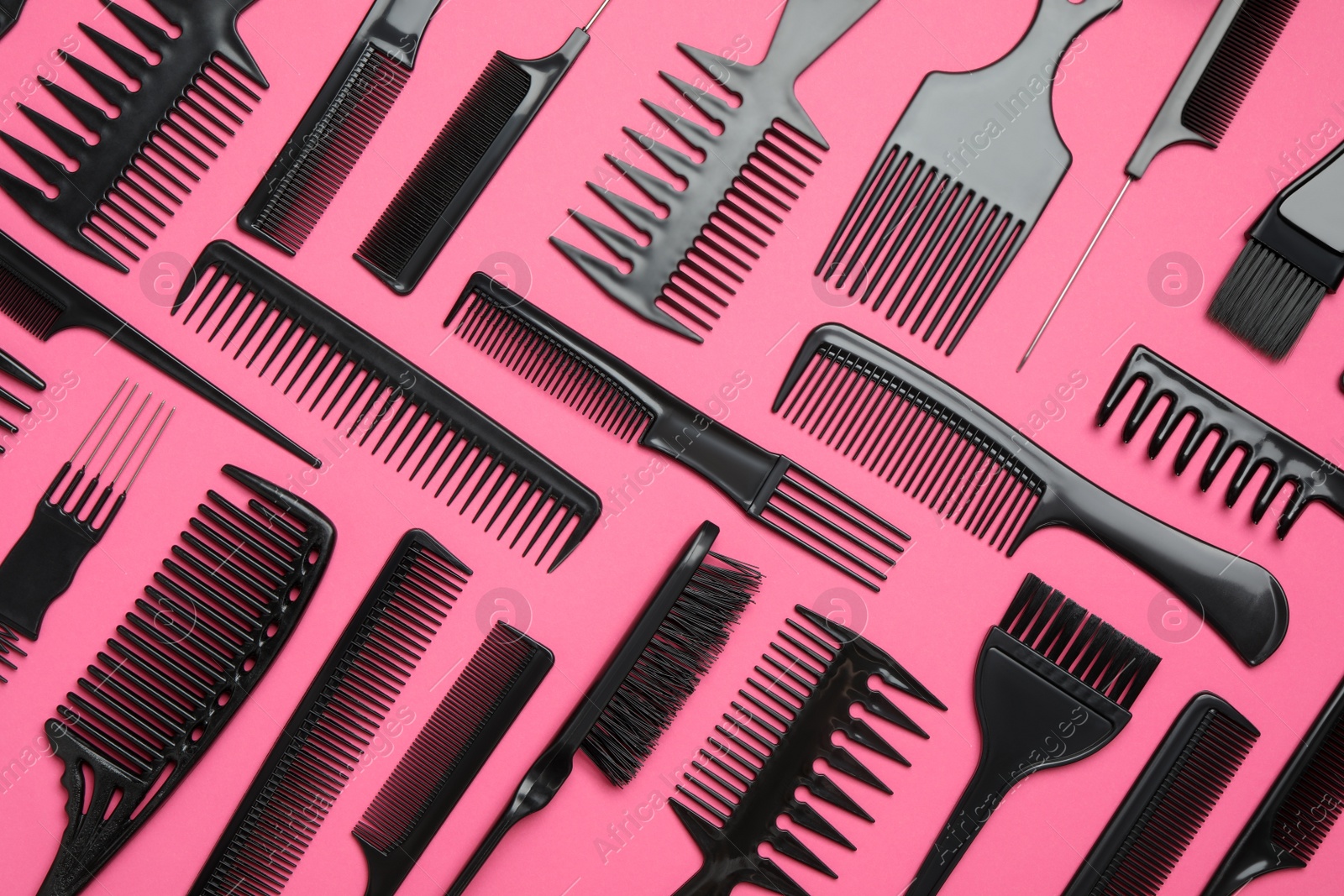 Photo of Flat lay composition with modern hair combs on pink background