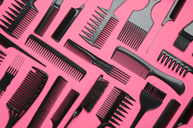 Photo of Flat lay composition with modern hair combs on pink background