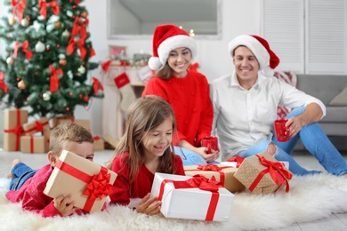 Happy parents with children and gifts at home. Celebrating Christmas