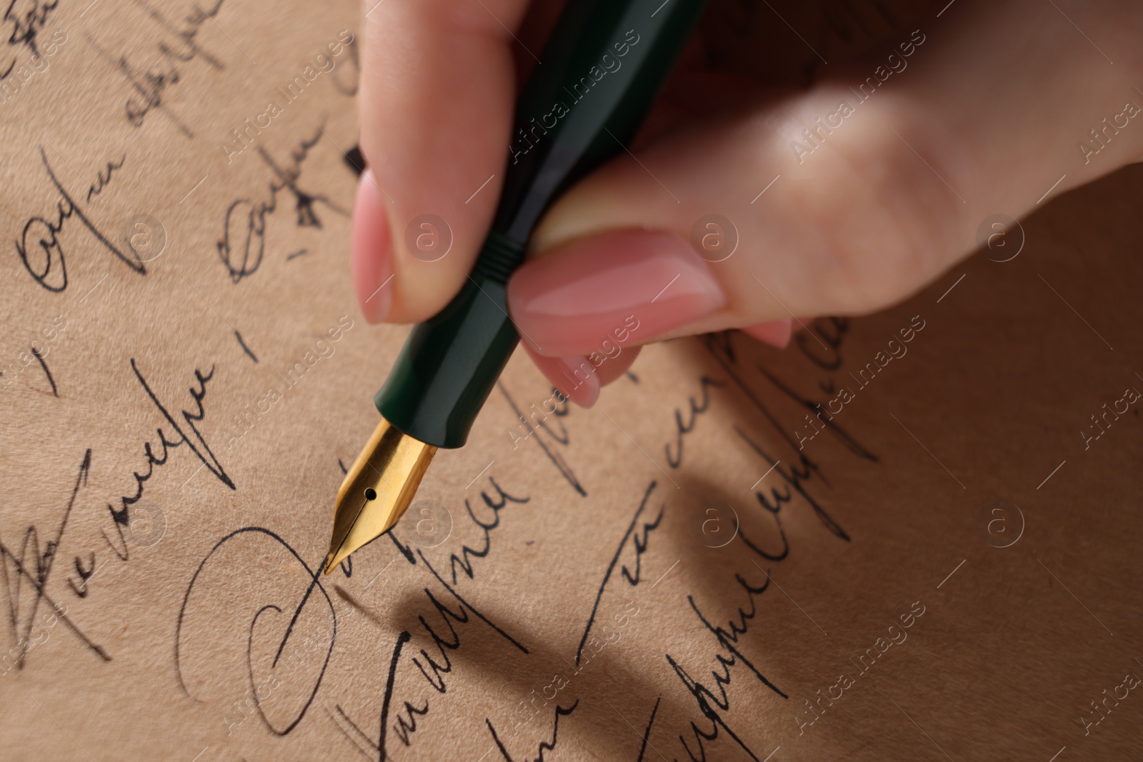 Photo of Woman writing letter with fountain pen, closeup