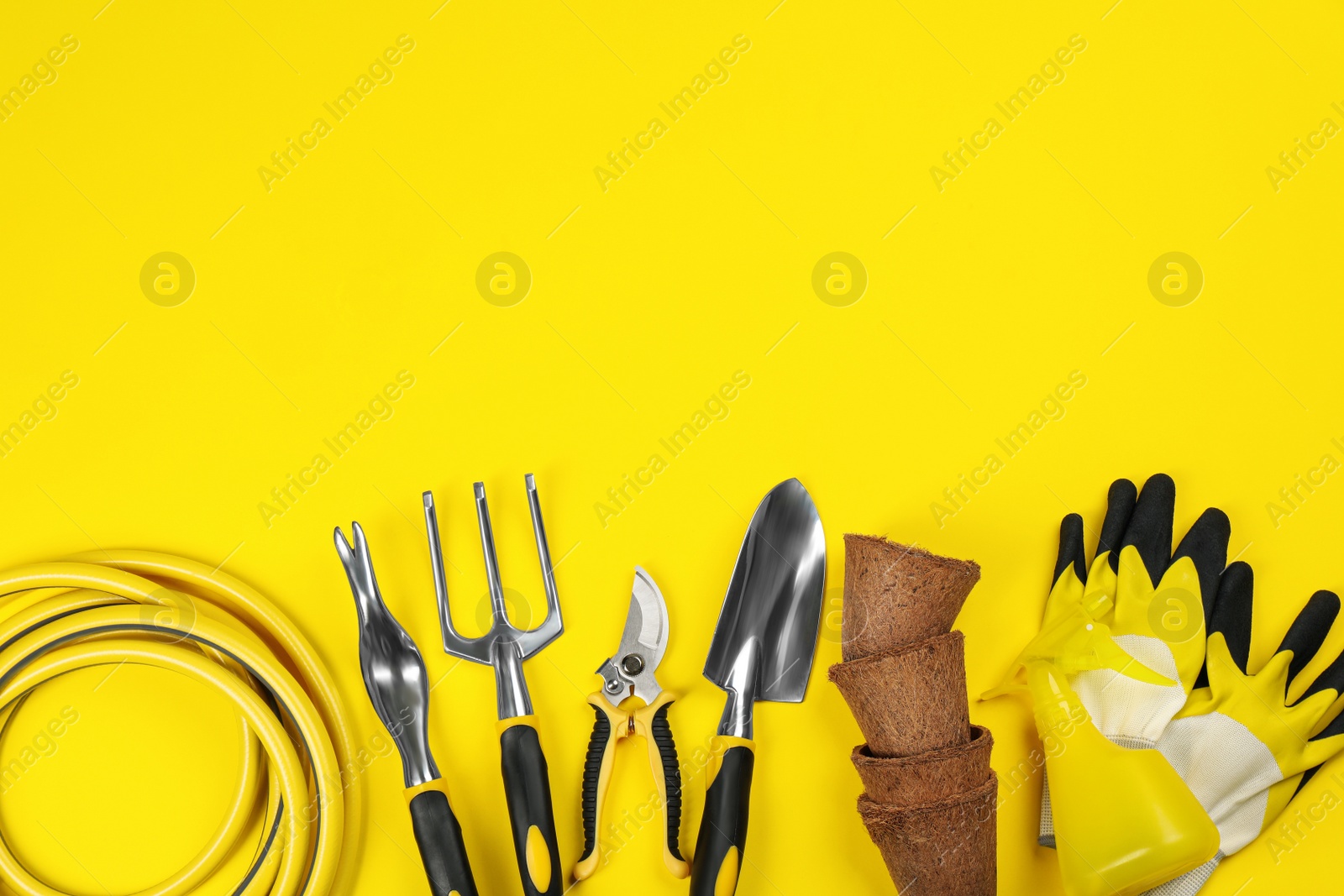 Photo of Flat lay composition with gardening tools on yellow background, space for text