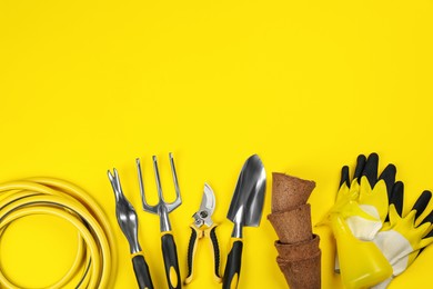 Flat lay composition with gardening tools on yellow background, space for text