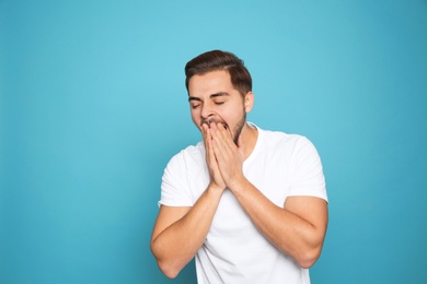 Portrait of young man laughing on color background