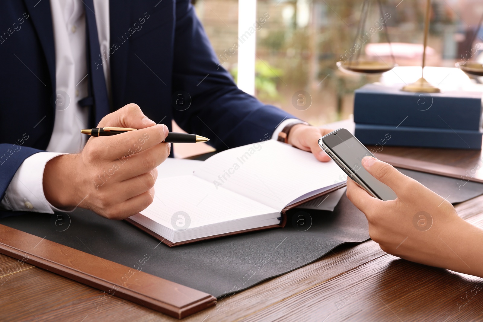 Photo of Lawyer working with client at table in office, focus on hands