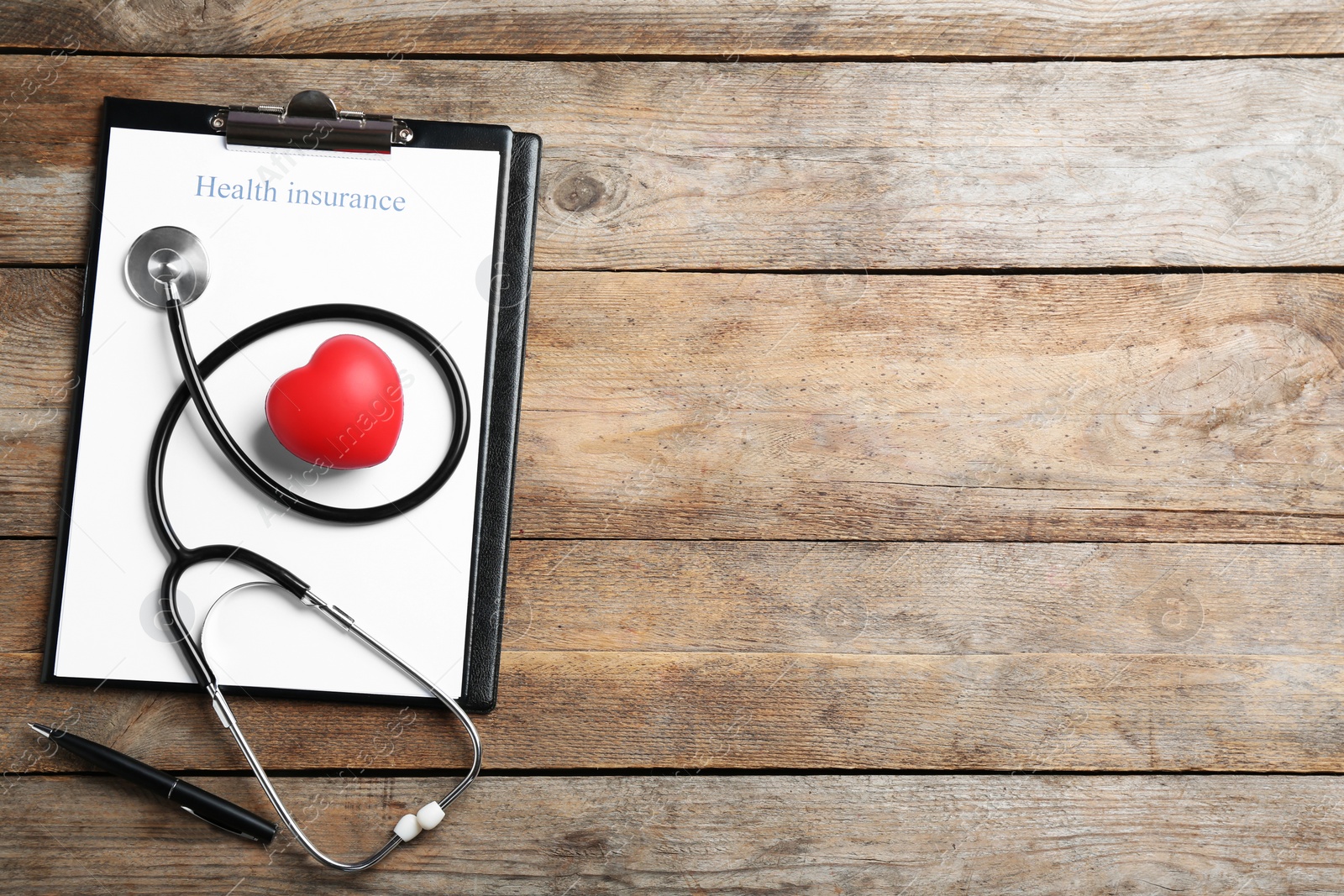 Photo of Flat lay composition with health insurance form and stethoscope on wooden background, space for text