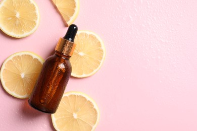 Photo of Bottle of cosmetic serum and lemon slices on wet pink background, flat lay. Space for text