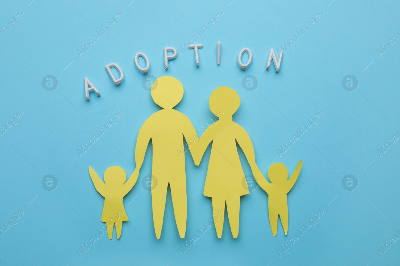 Photo of Family figure and word Adoption on light blue background, flat lay