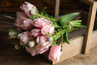Photo of Beautiful bouquet of spring pink tulips on wooden table, closeup