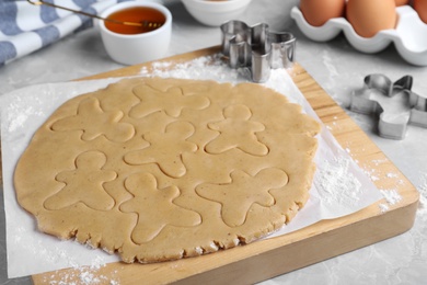 Photo of Making homemade Christmas cookies. Dough for gingerbread men on light grey marble table, closeup