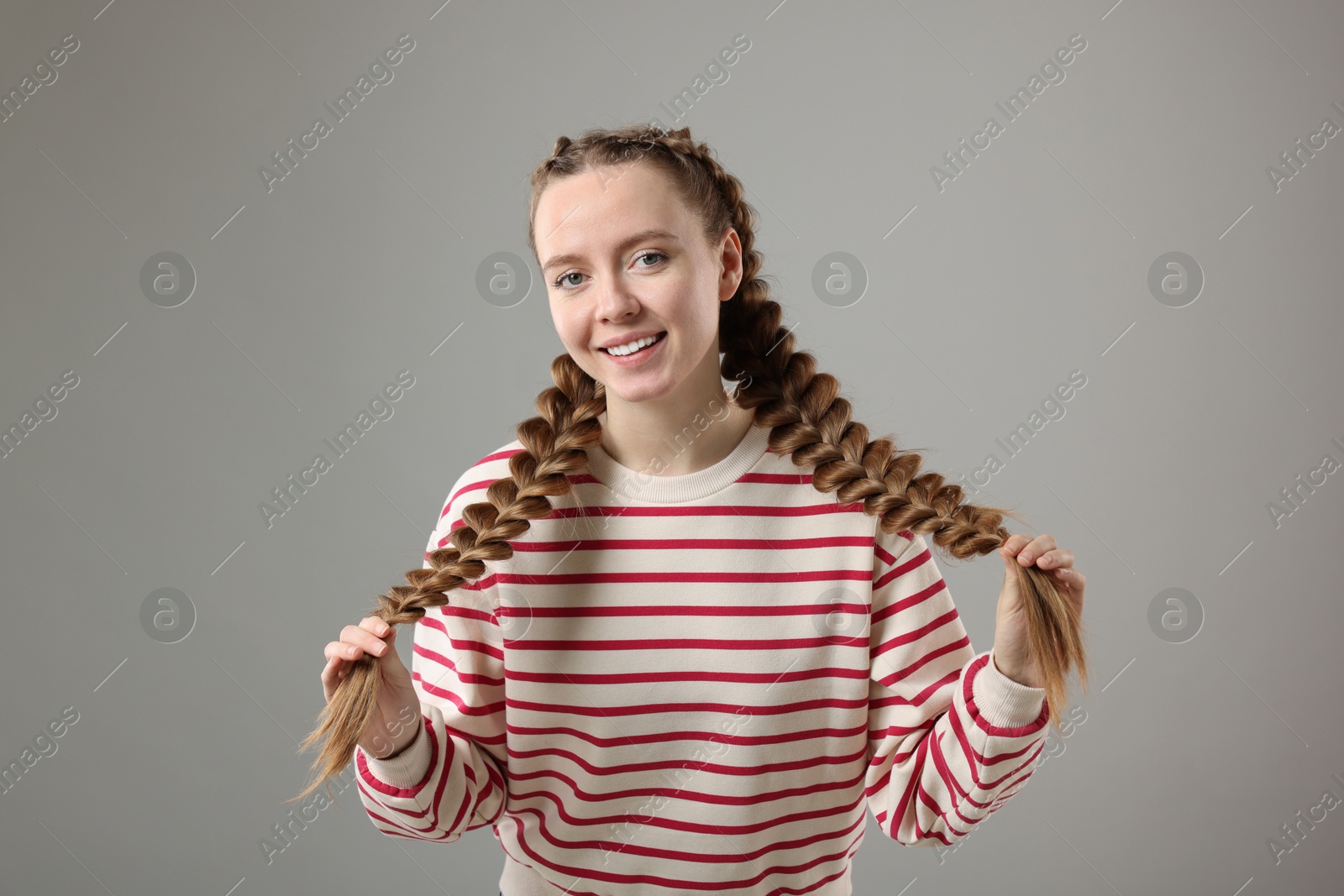 Photo of Woman with braided hair on grey background