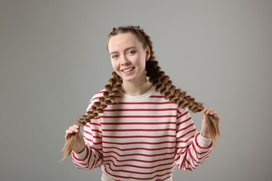 Photo of Woman with braided hair on grey background